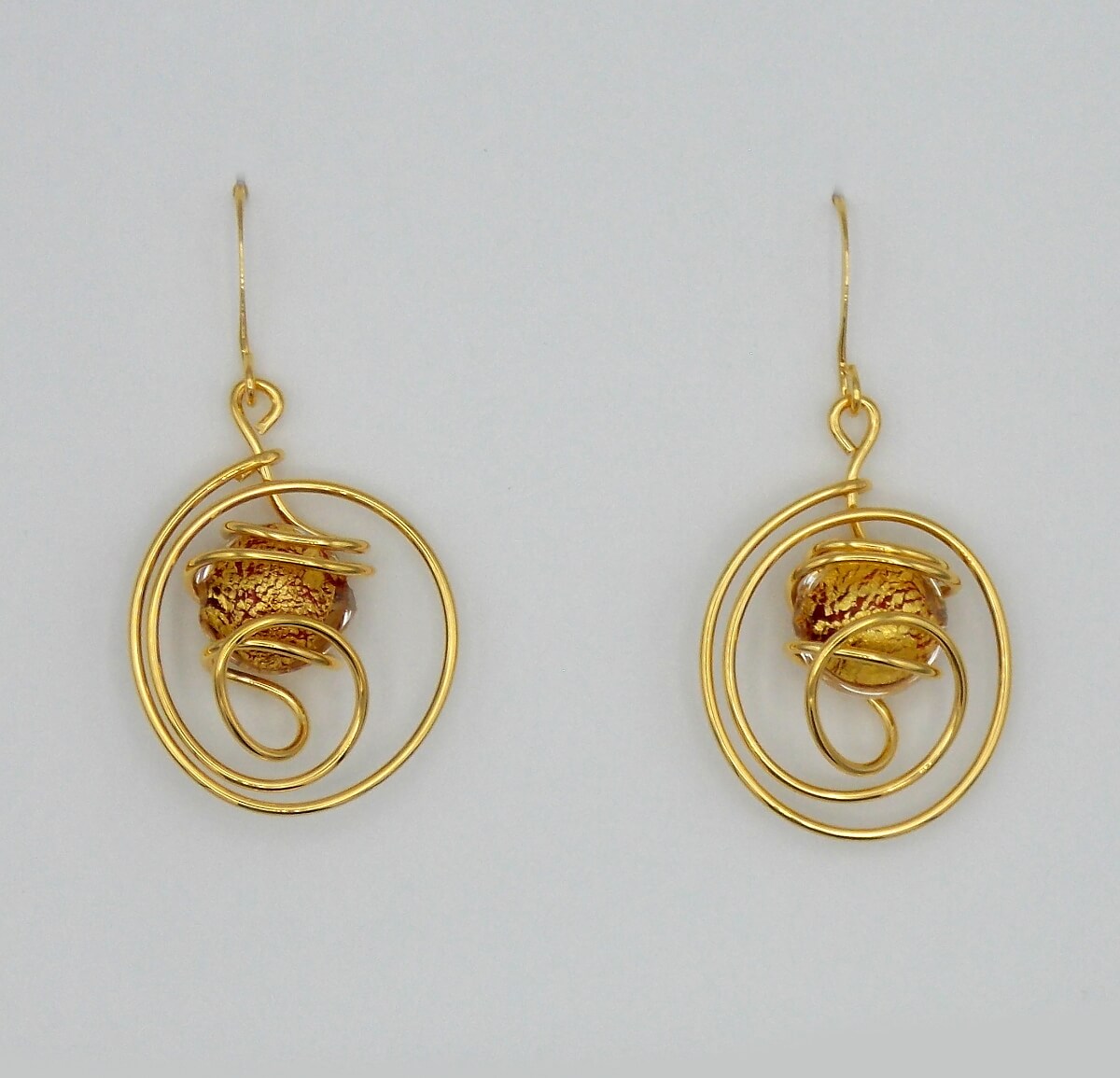 Gold rhodium metal swirled drop earrings with Murano glass gold and red glass bead