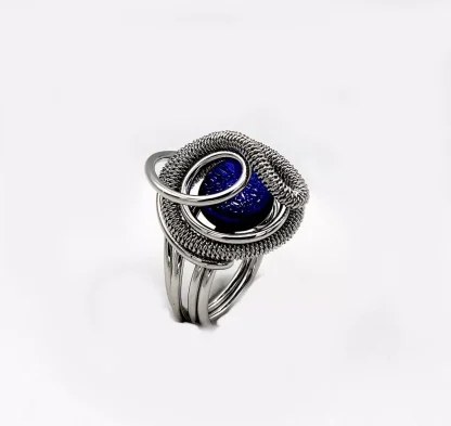 swirling silver tone rhodium ring with a mounted bllue Murano glass bead