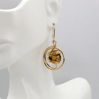 Swirling metal drop gold earring with a Murano gold and black speckled Murano glass bead