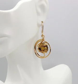 Swirling metal drop gold earring with a Murano gold and black speckled Murano glass bead