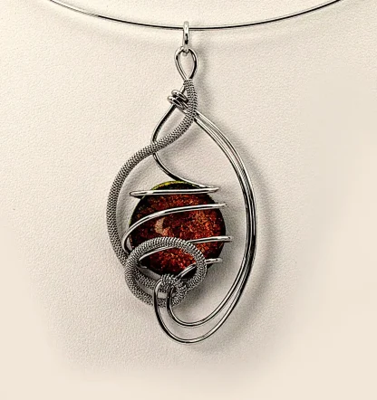 Arabesque shape silver pendant with a fiery bronze Murano glass bead close up