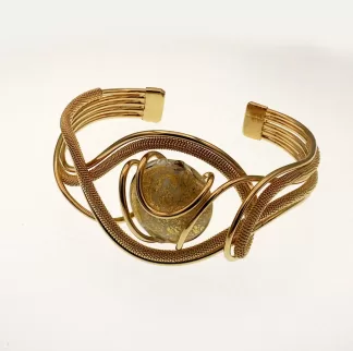 Golden serpentine shaped cuff bracelet with multi-strands of metal, wrapped wire and a gold Murano glas bead