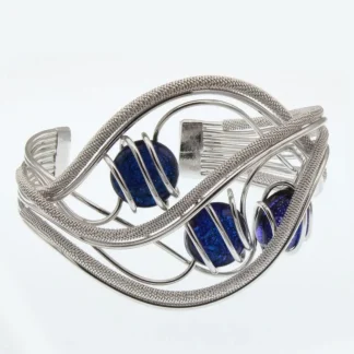 silver tone cuff bracelet in wrapped wire, hand tooled rhodium in an elaborate wave design wit three royal blue Murano glass beads