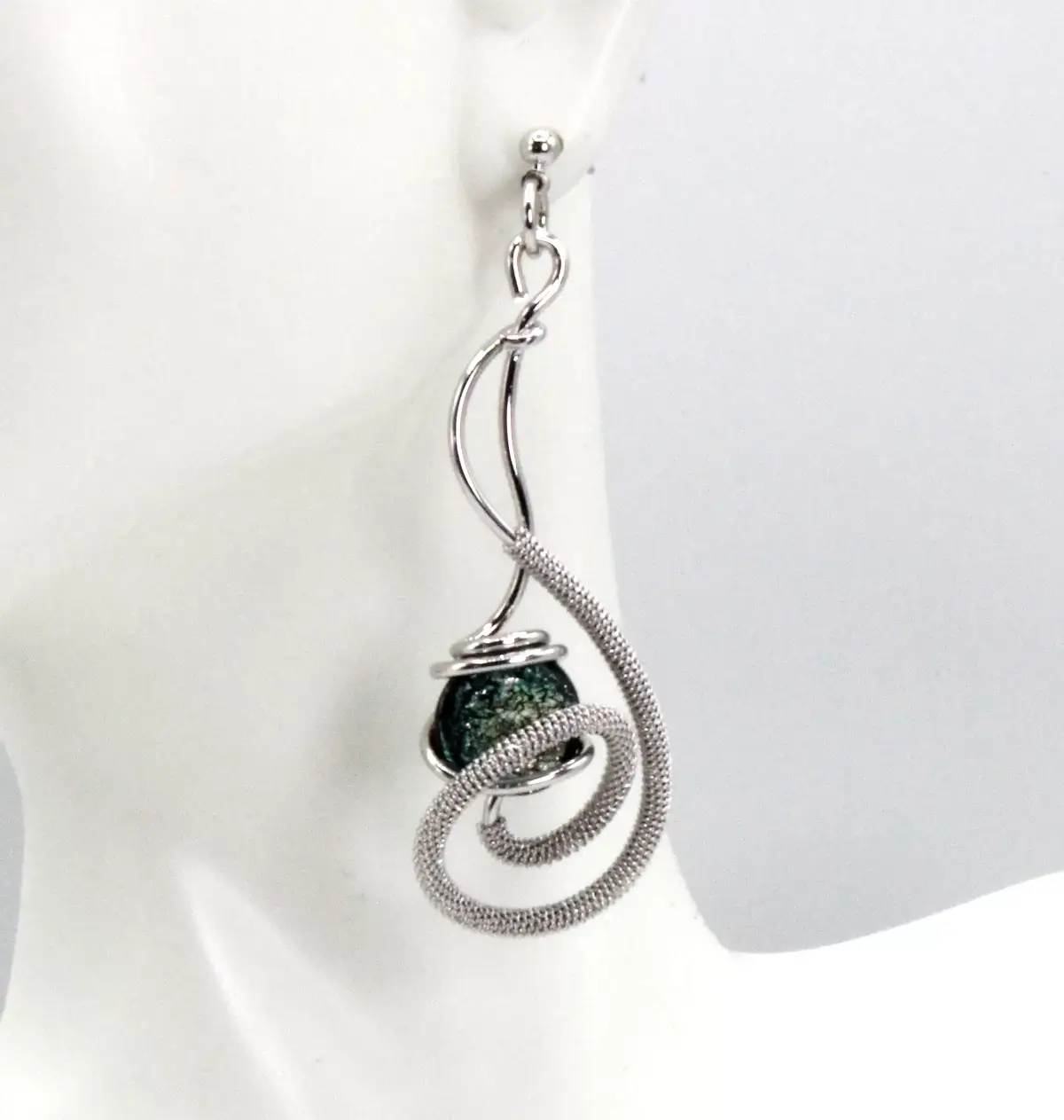 Swirl long earring detailed wire wrapped rhodium with a sparkling green Murano glass bead