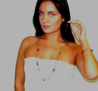 Murano glass multicolor glass beads interspersed on a long beveled chrome chain reflecting light matching on earrings and bracelet on model