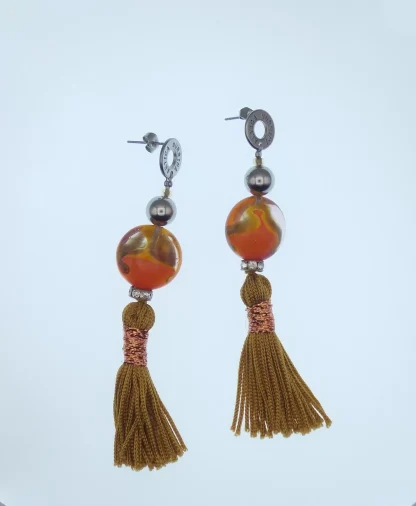 Murano drop earring with a large orange and copper round bead and an orange silk tassel