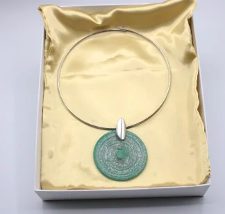 model wearing green with silver highlights Murano glass large disc pendant, bracelet and matching earrings