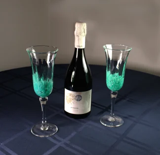 Murano champagne flutes on a table with a bottle of champagne
