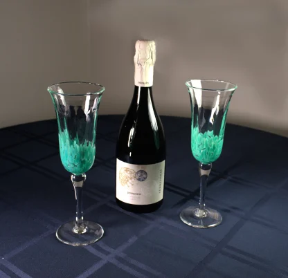 Murano champagne flutes on a table with a bottle of champagne