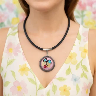 Pink Miro surreal art-look lady face is a 1 1/2 inch Murano glass bead with hand decorated face and gold leaf necklace with stainless steel frame and bail on a 16 inch rubber cord