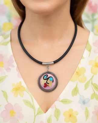 Pink Miro surreal art-look lady face is a 1 1/2 inch Murano glass bead with hand decorated face and gold leaf necklace with stainless steel frame and bail on a 16 inch rubber cord