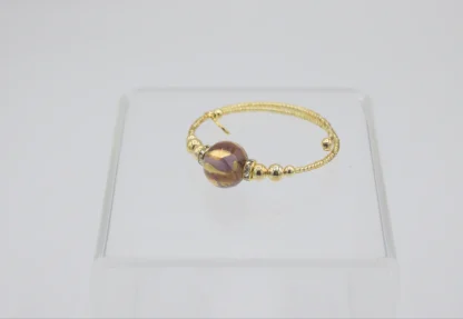 Murano wrap bracelet in gold seed beads, one large round glass bead of gold, caramel and purple with mini bling