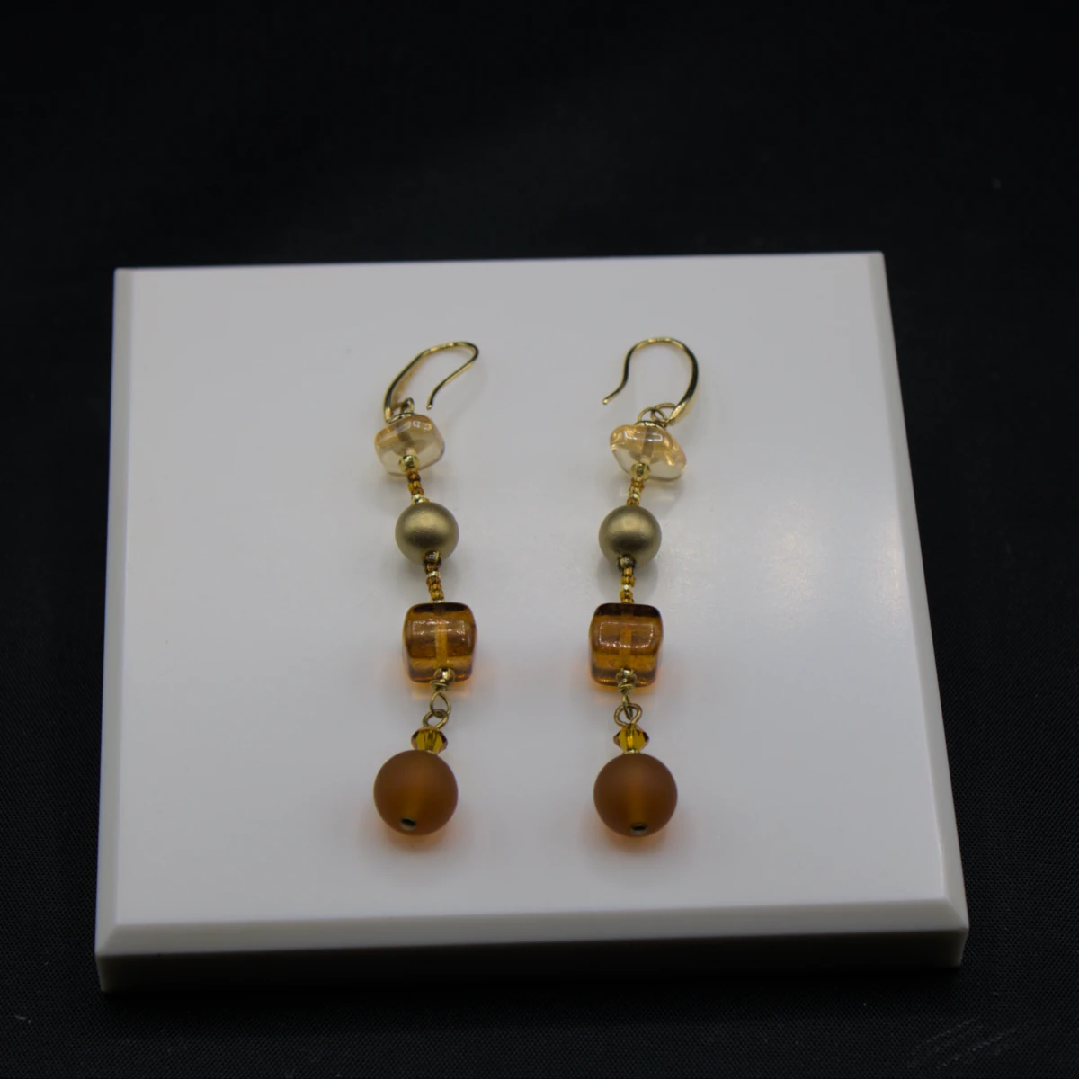 Murano long drop amber tone earrings. Four different types of Murano glass on a three inch drop with additional small glass detail in between them.