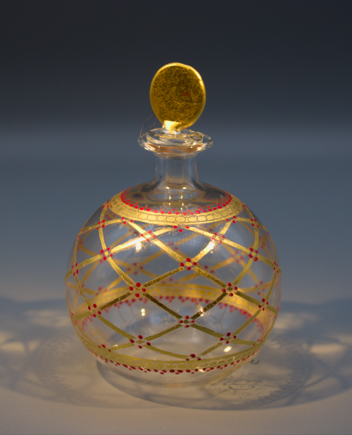 Murano blown glass delicate round scent or perfume bottle with gold lattice design, dotted with red.