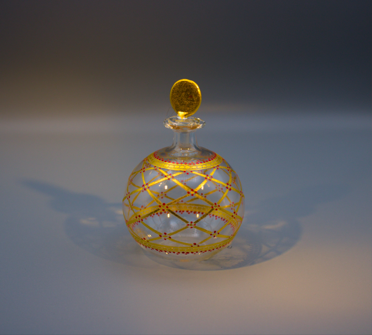 Murano blown glass delicate round scent or perfume bottle with gold lattice design, dotted with red.